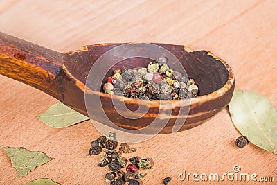 Old-fashioned wood spoon with spices and bay leaves