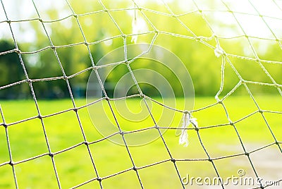 The Old Football Gate with hole, on background of green fields