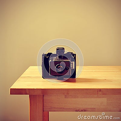 Old instant camera on a table, with a retro effect