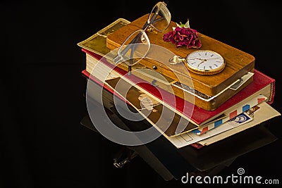 Old letters, glasses, dried rose, pocket watch all on a black background with blank space