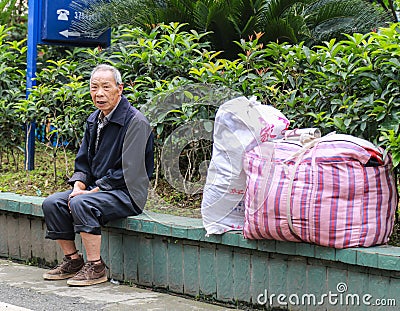 Old man at the bus stop in gao miao,sichuan,china