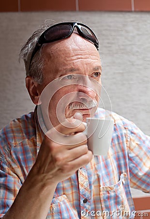 Old man drinking cup of coffee