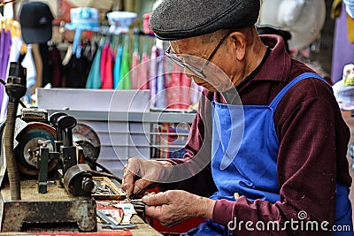 The old man granding keys in yuantong town in sichuan,china