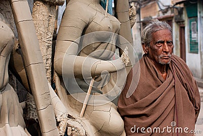 Old man stands near the woman sculpture