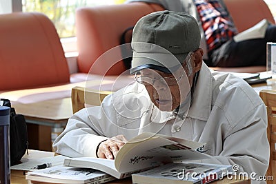 Old man studying in library