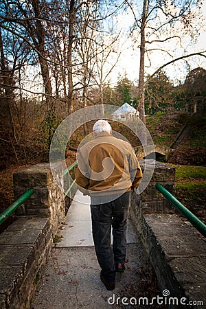 Old Man Walking Across a Bridge Outside