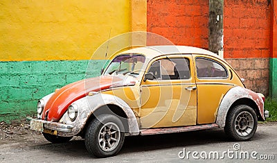 Old Mustard and Red Bug in Front of Colorful Wall