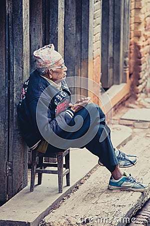 Old Nepalese man sitting in front of his home in Nepal