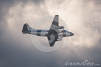 Old passenger plane on cloudy sky