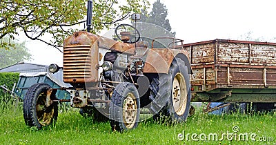 Old rusty farm tractor with trailer