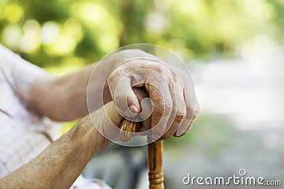 An old s man hands holding cane. Close up concept.
