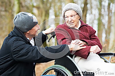 Old senior woman in wheelchair with careful son