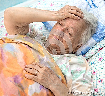 Old sick woman lying at bed