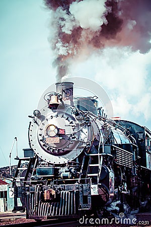 Old steam locomotive against blue cloudy sky, vintage train