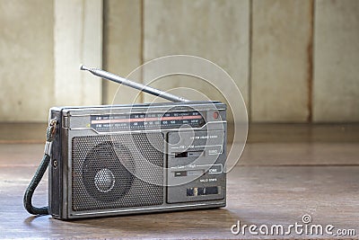 Old transistor radio on wood background.