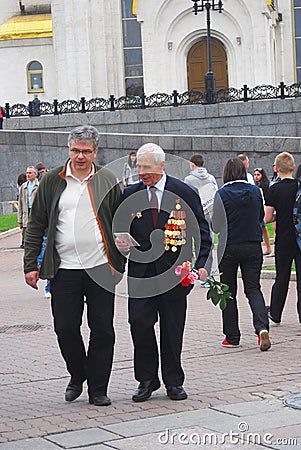 Old war veteran walking with flowers