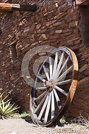 Old wheel near a stone wall