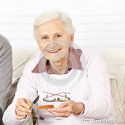 Old woman buttering a toast for