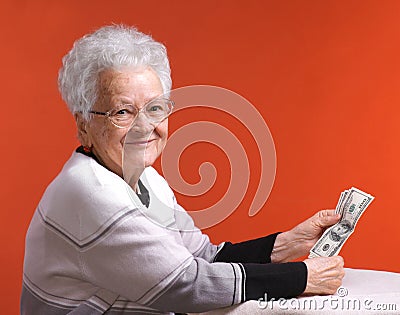 Old woman in glasses holding money