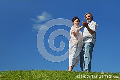 Old woman and man dancing on lawn
