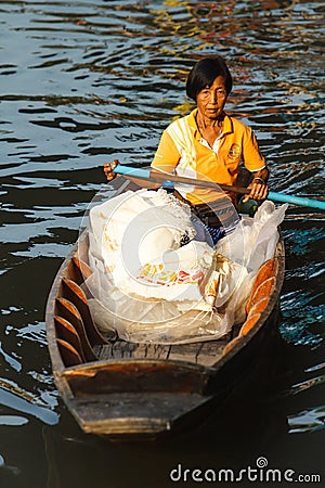 Old woman paddling wooden boat