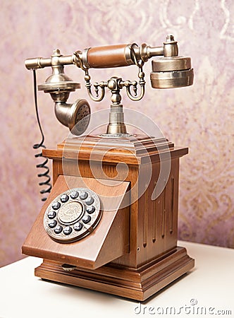 Old wooden phone. Vintage wooden telephone on white table. Retro