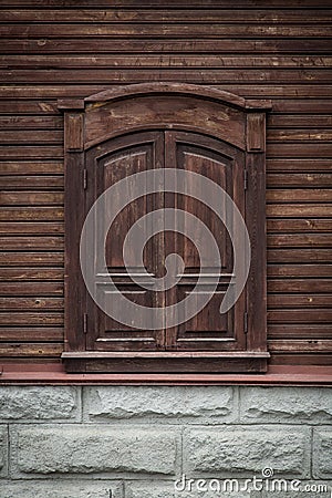 Old wooden window with carved wooden ornaments. Closed window.