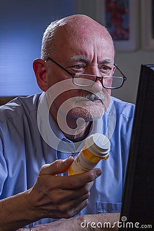 Older man refilling prescription online, vertical