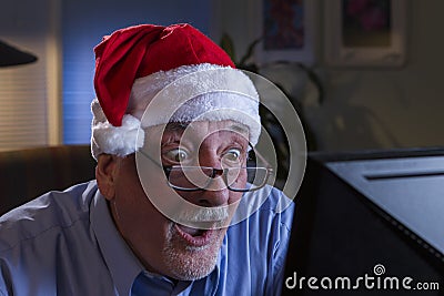 Older man in Santa hat looking shocked, horizontal