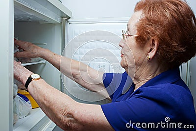 Older woman looking for food in the fridge