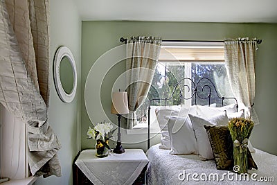 Olive tones bedroom with antique iron frame bed