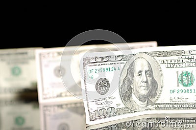 One hundred dollar bills on the black background.