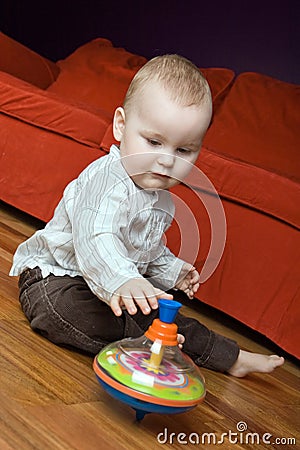 One year old boy playing with his spinning top.