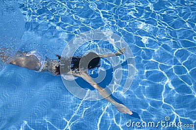 Open arms woman diving in a pool