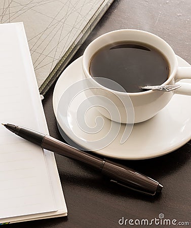Open a blank white notebook, pen and cup of coffee