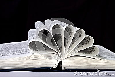 Open book with the pages curled on a black