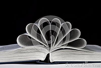 Open book with the pages curled on a black