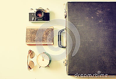 Open case with old camera sunglasses and clock.