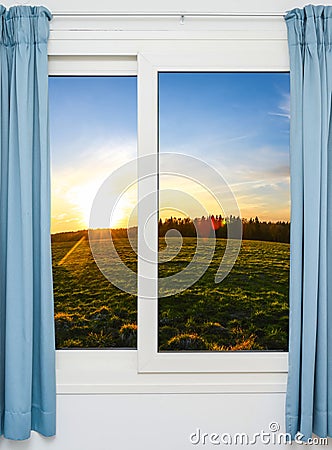 Open door with green meadow illuminated by bright sunshine