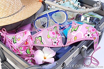Open suitcase with vacation items