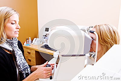 Optician testing eye pressure on client