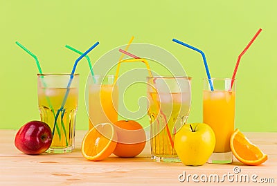 Orange and apple juices on wooden table.