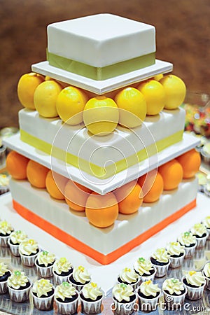 Orange Lemon 3 tier white wedding cake with mini cupcakes