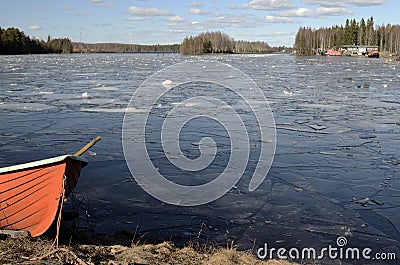 Orange rescue boat on the shore of a frozen lake