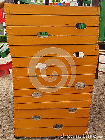 Orange wooden climbing wall ladder on kids playground