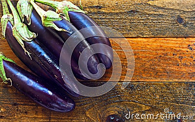 Organic aubergines on rustic wooden table