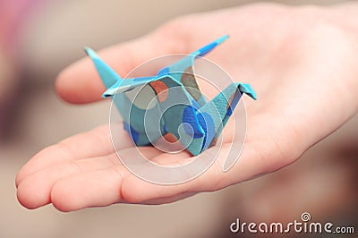 Origami crane on child hand