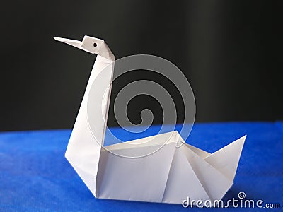 Origami swan on blue background