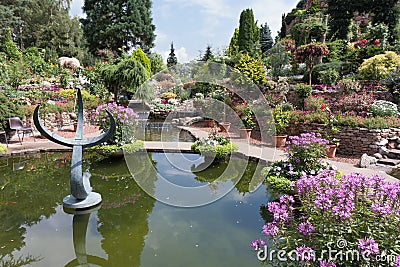 Ornamental garden with pond and blooming flowers