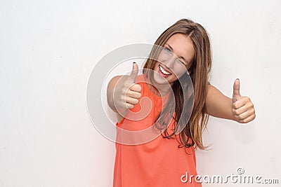 Outdoor portrait of teenage girl showing thumbs up